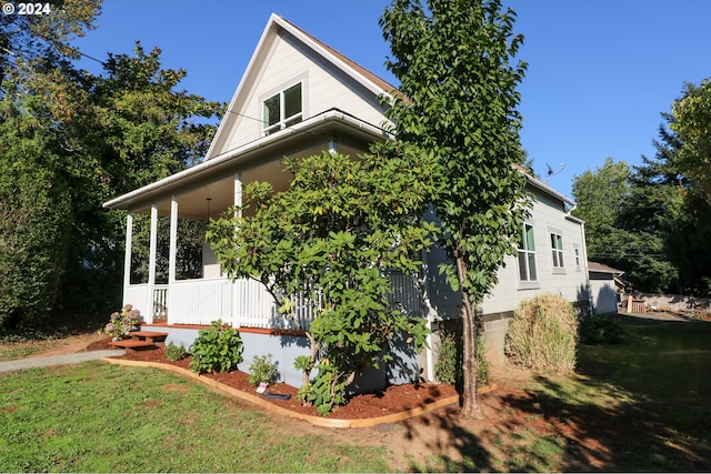 view of home's exterior featuring covered porch and a lawn