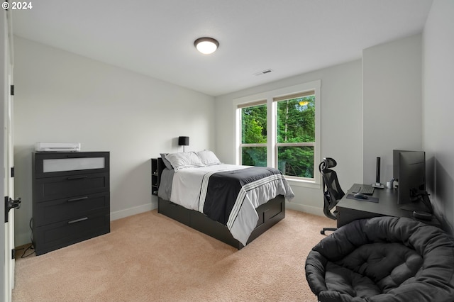 bedroom featuring light carpet and multiple windows