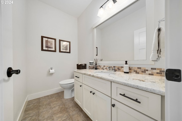 bathroom featuring vanity, backsplash, and toilet