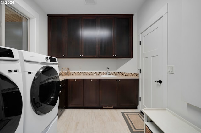 laundry room featuring separate washer and dryer, sink, and cabinets