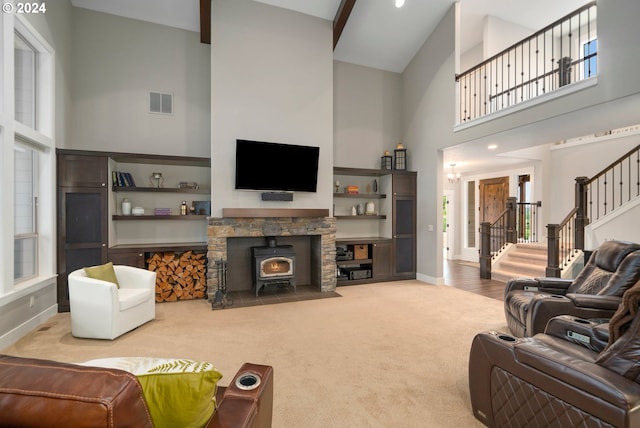 carpeted living room with a towering ceiling and a wood stove