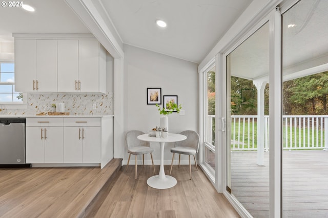 dining room with light wood-type flooring and vaulted ceiling