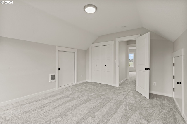 additional living space featuring light carpet and vaulted ceiling