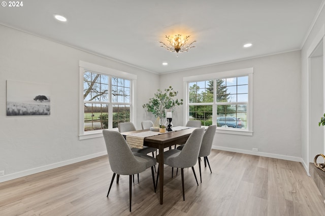 dining area with crown molding and light hardwood / wood-style floors