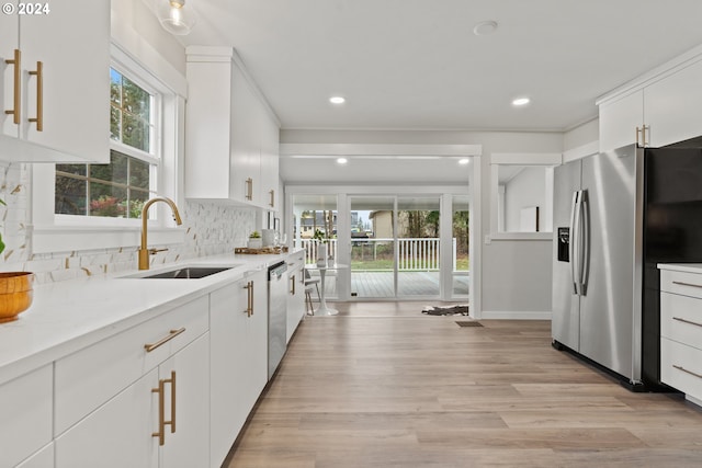 kitchen featuring white cabinets, stainless steel appliances, a healthy amount of sunlight, and sink