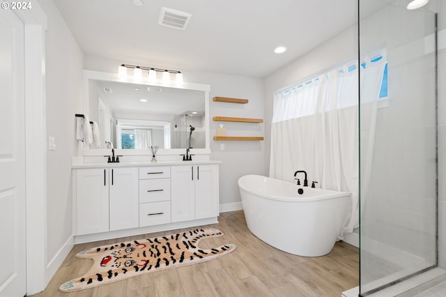 bathroom featuring wood-type flooring, vanity, separate shower and tub, and a healthy amount of sunlight