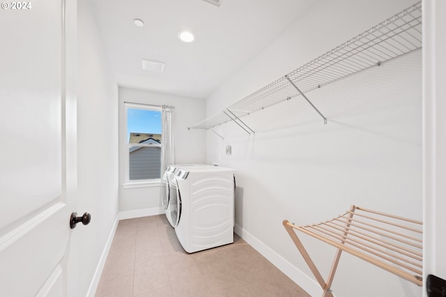 laundry room featuring washing machine and dryer and light tile patterned floors