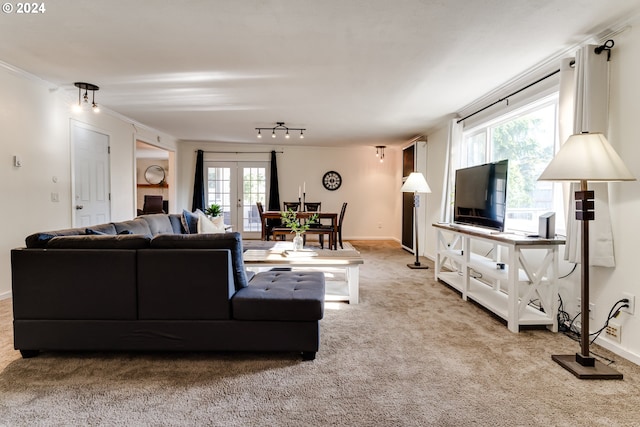 living room with ornamental molding, french doors, and light carpet