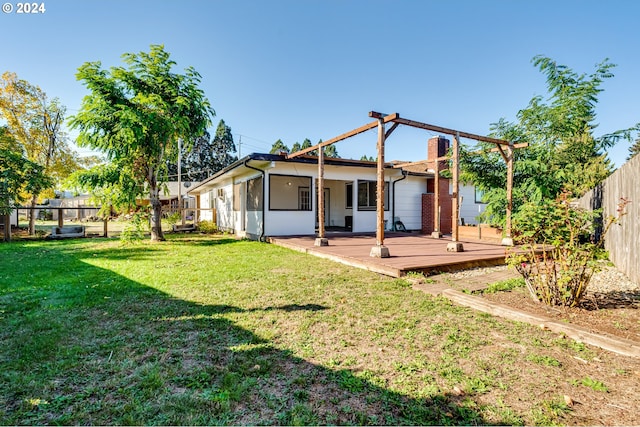 rear view of house with a yard, a deck, and a sunroom