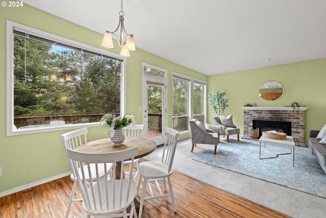 sunroom / solarium featuring a brick fireplace and a notable chandelier