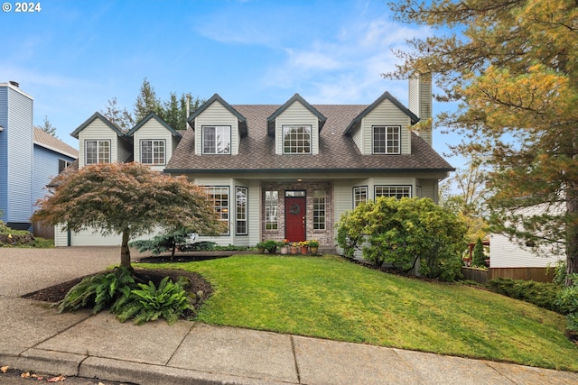 cape cod-style house featuring a garage and a front lawn