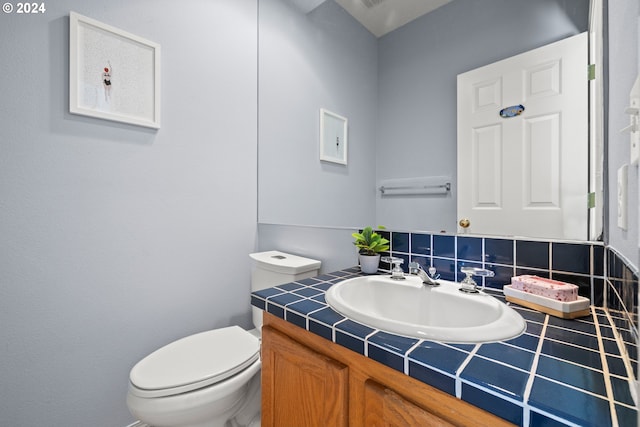 bathroom with vanity, backsplash, and toilet