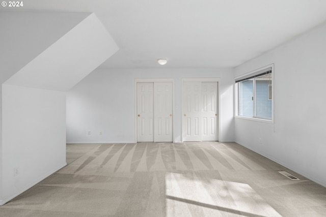 bonus room featuring light carpet and vaulted ceiling