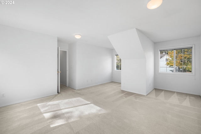 bonus room featuring plenty of natural light and light colored carpet