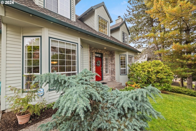 property entrance featuring a lawn