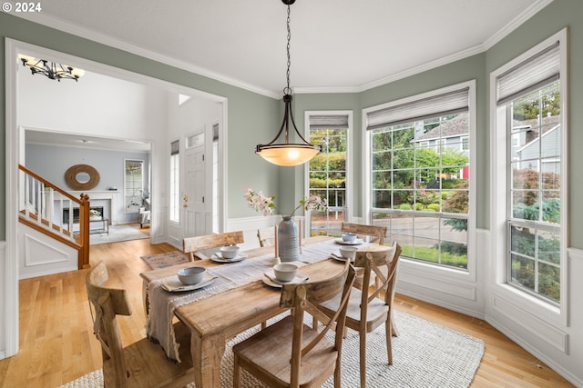 dining room with light hardwood / wood-style floors, ornamental molding, and a wealth of natural light