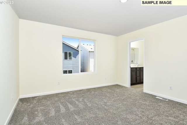 unfurnished room with visible vents, light colored carpet, and baseboards