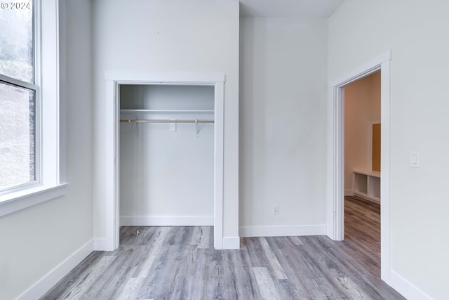 unfurnished bedroom with a closet and light hardwood / wood-style floors