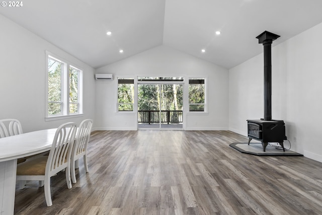 dining room with lofted ceiling, hardwood / wood-style floors, and a wood stove