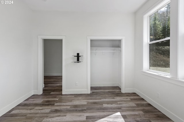 unfurnished bedroom featuring dark hardwood / wood-style floors and a closet