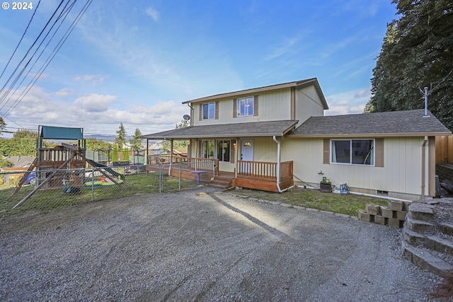 view of front of home featuring a playground and covered porch