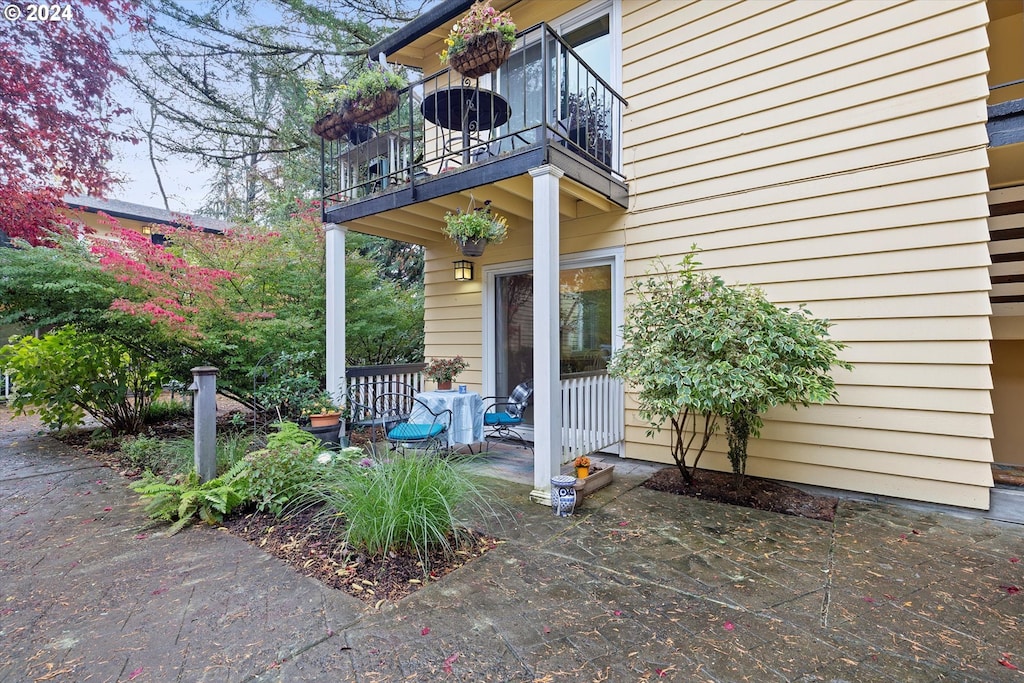 view of exterior entry with a balcony and a patio area