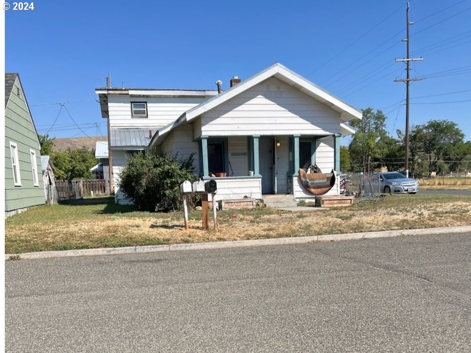 bungalow featuring covered porch and fence