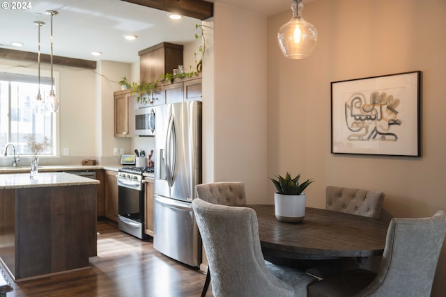 dining room featuring an inviting chandelier, dark hardwood / wood-style flooring, and beamed ceiling