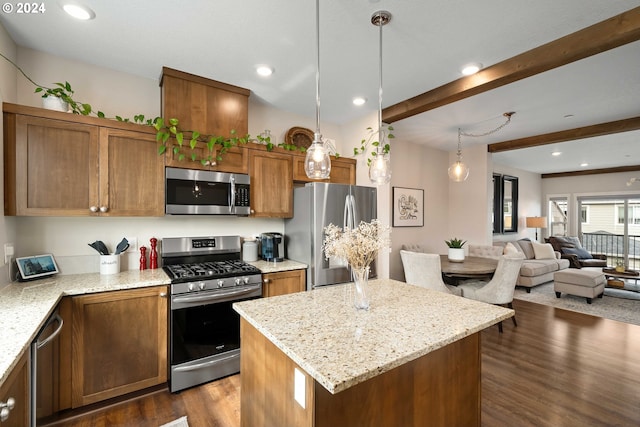 kitchen featuring light stone counters, a center island, dark wood-type flooring, hanging light fixtures, and appliances with stainless steel finishes