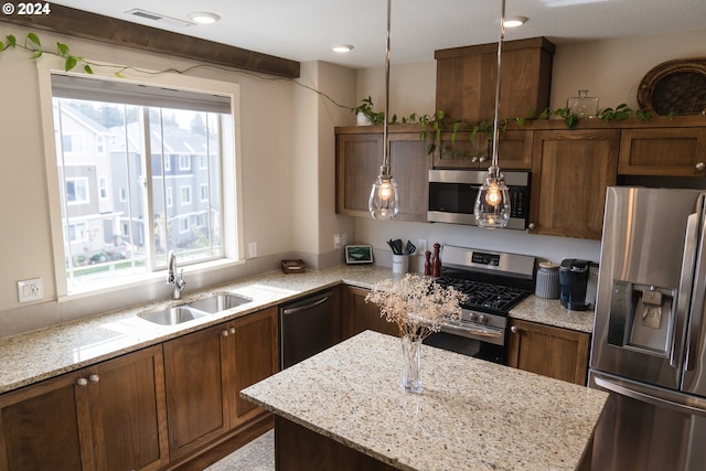 kitchen featuring pendant lighting, stainless steel appliances, a wealth of natural light, and sink