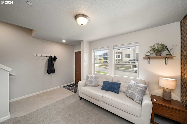 tiled living room featuring a textured ceiling