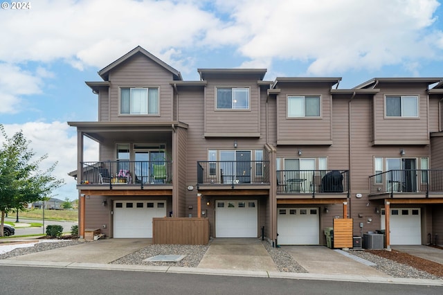 multi unit property with a balcony, cooling unit, and a garage