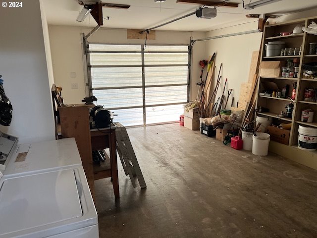 garage with a garage door opener and washing machine and clothes dryer