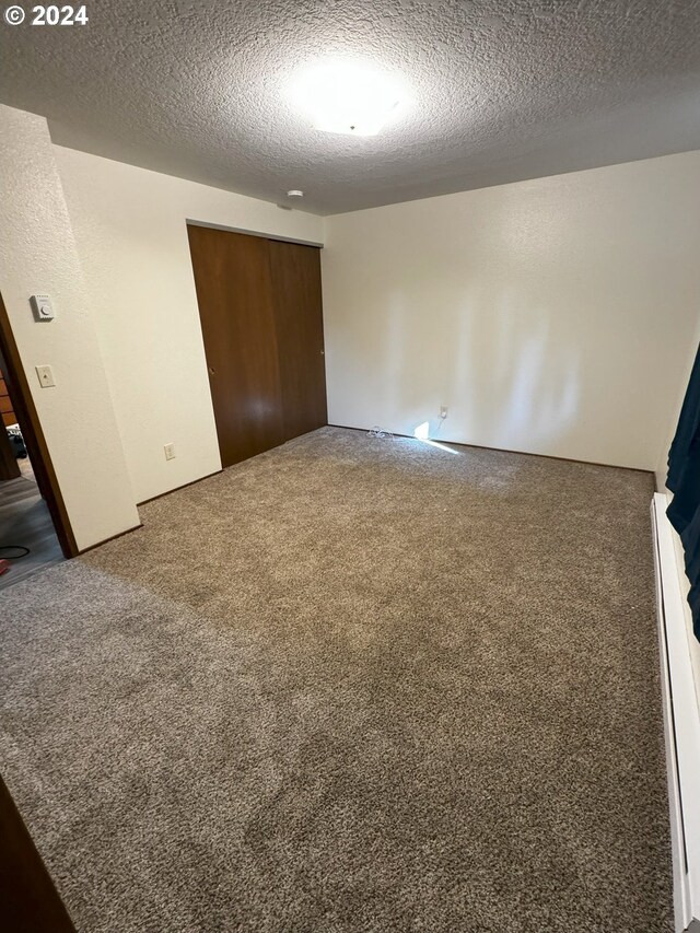 empty room featuring carpet and a textured ceiling