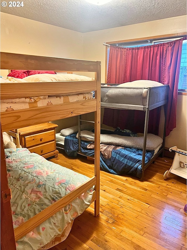 bedroom featuring a textured ceiling and hardwood / wood-style flooring