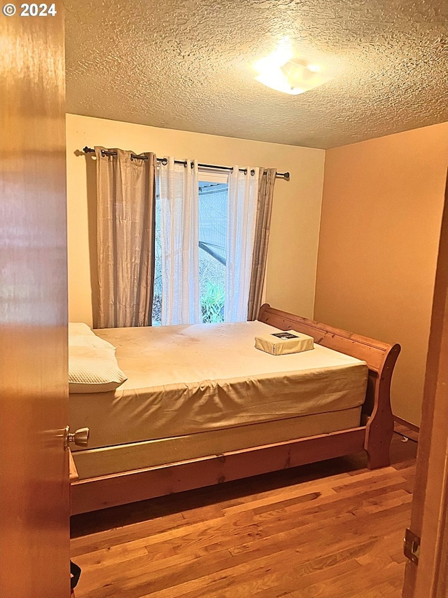 unfurnished bedroom with hardwood / wood-style flooring and a textured ceiling