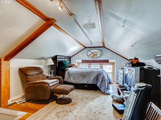 bedroom featuring track lighting, wood-type flooring, crown molding, and vaulted ceiling