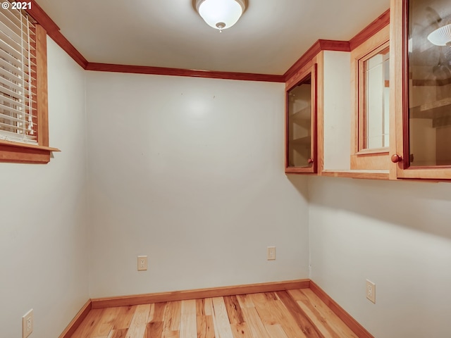 unfurnished room with crown molding and light wood-type flooring