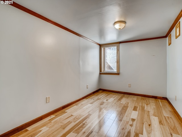 empty room with light hardwood / wood-style floors and ornamental molding