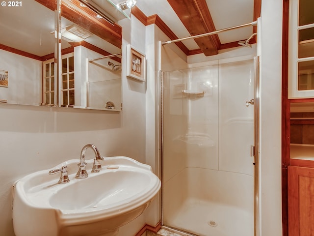 bathroom featuring beamed ceiling, a shower with door, and sink