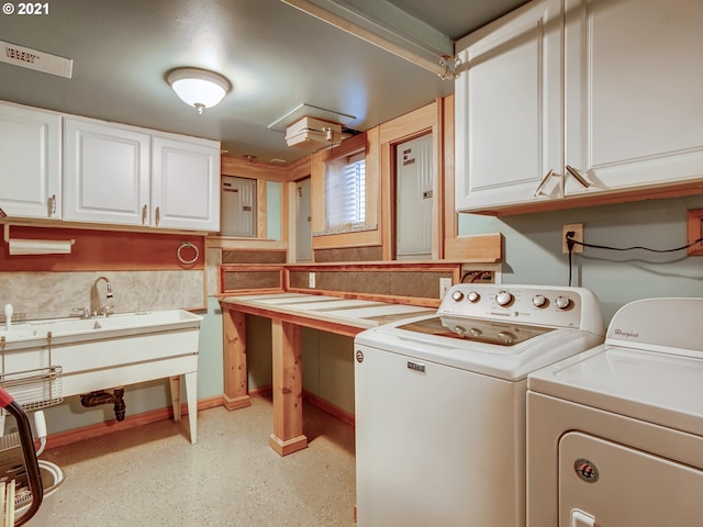 laundry area featuring washer and clothes dryer and cabinets