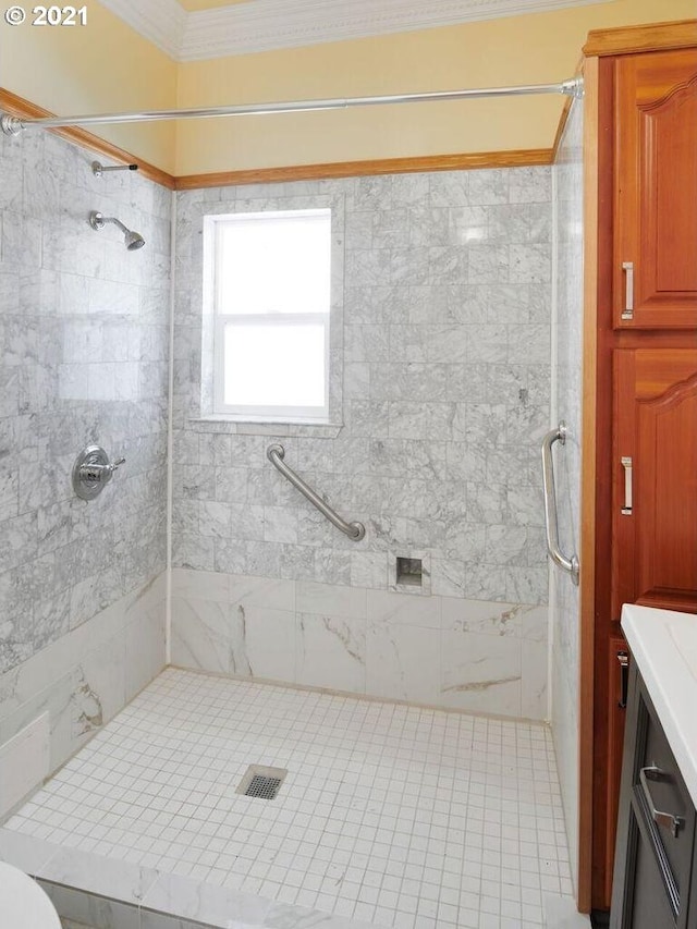 bathroom with tile patterned floors, vanity, ornamental molding, and tiled shower