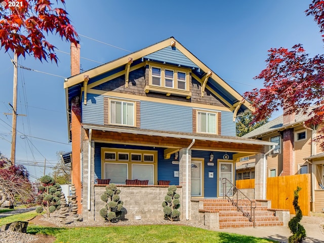 view of front of property featuring a porch and fence