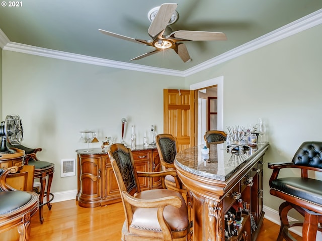 bar featuring light hardwood / wood-style floors, light stone counters, and crown molding