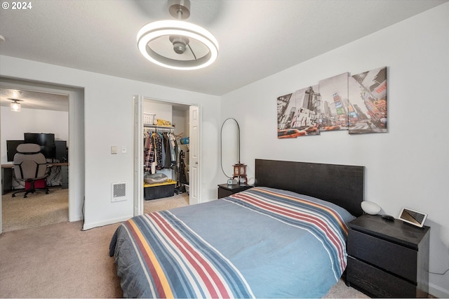 carpeted bedroom with a closet and a spacious closet