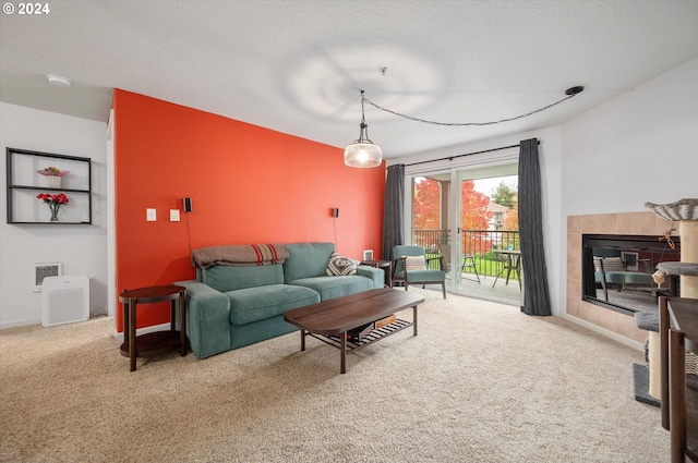 living room featuring a fireplace, a textured ceiling, and carpet floors