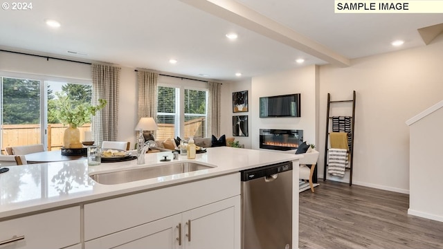 kitchen featuring stainless steel dishwasher, plenty of natural light, white cabinets, and sink