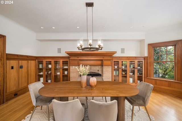 dining area with light hardwood / wood-style floors and a chandelier