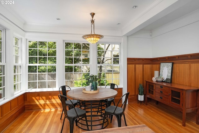 dining room featuring a wealth of natural light, crown molding, and light hardwood / wood-style flooring