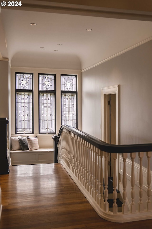 hallway with a healthy amount of sunlight, vaulted ceiling, and dark hardwood / wood-style flooring